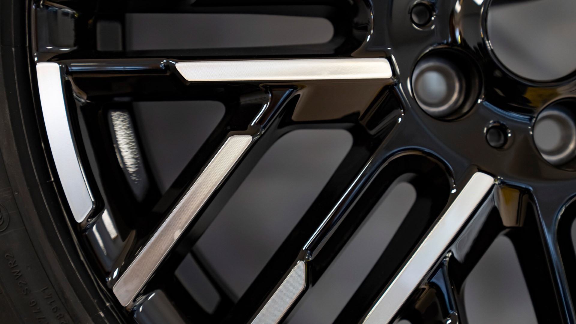 Gros plan de la jante en alliage noir et argent du MINI Cooper 100 % électrique avec finition brillante.